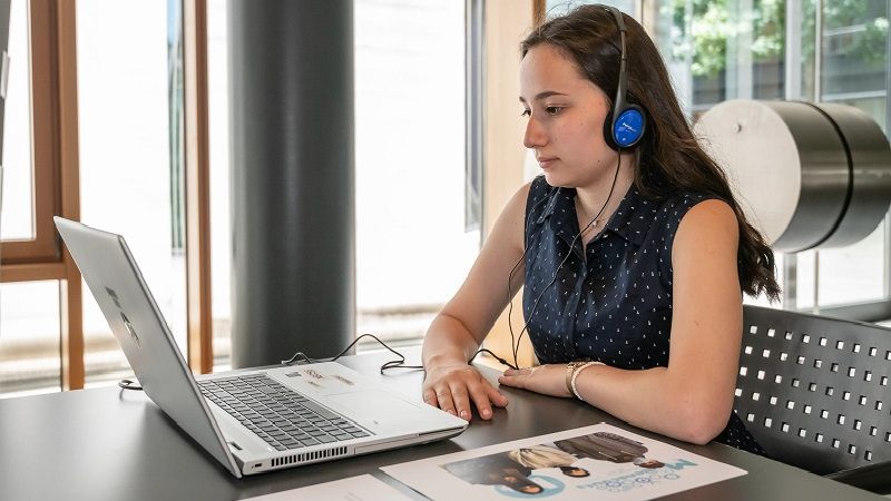 Junge Schülerin am Laptop bei der Ausstellungseröffnung der Preisträgerarbeiten des Schüler- und Jugendwettbewerbs 2022